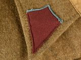 a brown jacket with a red patch on it