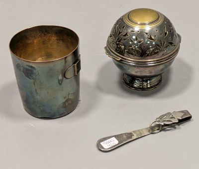 une tasse en argent et une cuillère posées l'une à côté de l'autre