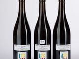 trois bouteilles de vin posées l'une à côté de l'autre sur une table