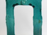 a green picture frame sitting on top of a white table