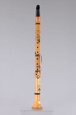 an orange and black clarinet on a clear stand