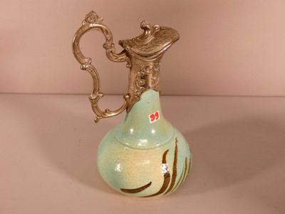 un petit vase muni d'une anse, posé sur une table