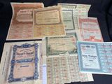 several different types of old paper certificates on a black surface