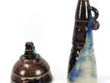 two vases sitting next to each other on a white surface