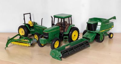 three toy tractors that are sitting on a table