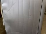 a white dishwasher sitting on the floor in a room