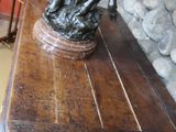 une statue en bronze représentant un garçon et une fille, posée sur une table