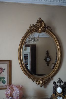 un miroir et une horloge posés sur une commode dans une pièce