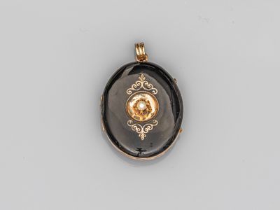 un pendentif doré et noir orné d'un diamant au centre