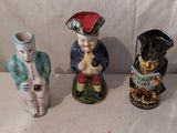 trois figurines assises l'une à côté de l'autre
