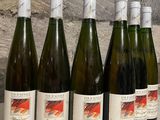six bottles of wine are lined up on a counter top