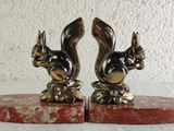 pair of brass squirrel bookends on red marble base