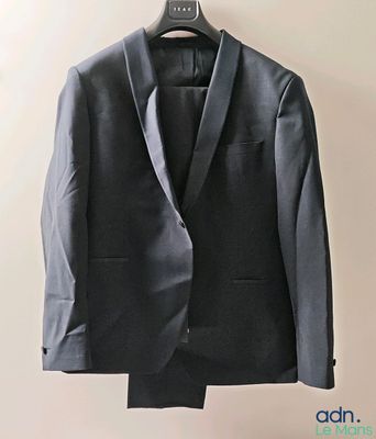 un costume suspendu à un cintre accroché au mur