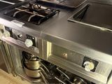 a kitchen with a stove, sink, and pot on the counter