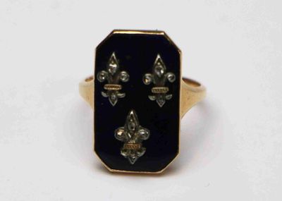 une image représentant une bague dorée et noire ornée de fleurons