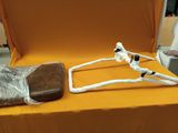 a skeleton sitting on a chair with a piece of wood on it