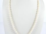 un gros plan d'un collier de perles blanches sur un mannequin