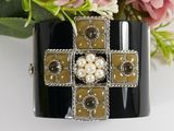 black and white bracelet with pearls and a cross on it