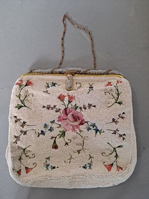 un vieux sac à main accroché au mur, entouré d'une corde