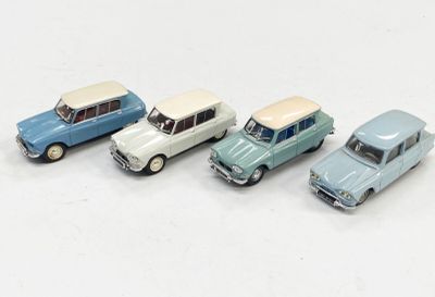 quatre petites voitures sont alignées sur une surface blanche
