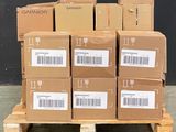 boxes stacked on a pallet in front of a black wall