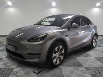 Le SUV Tesla argenté est garé sur un sol en carreaux à damier.