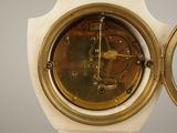 a clock that is sitting on a stand with a mirror