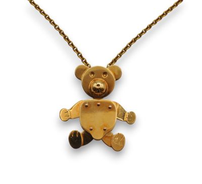 une photo d'un collier avec un ours en peluche en or suspendu à une chaîne