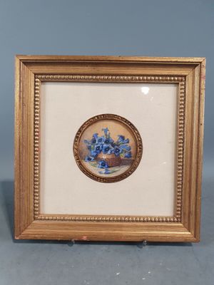 une photo représentant des fleurs bleues dans un cadre doré