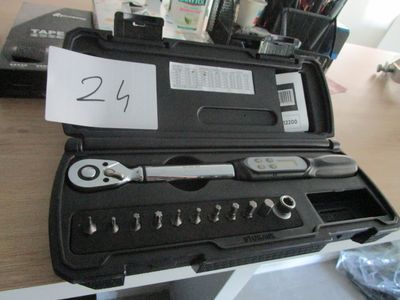 une mallette noire contenant des outils, posée sur un bureau