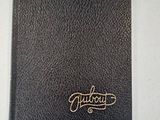 a black leather journal with a gold logo on it
