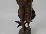 bronze statue of a woman playing a harp on a pedestal