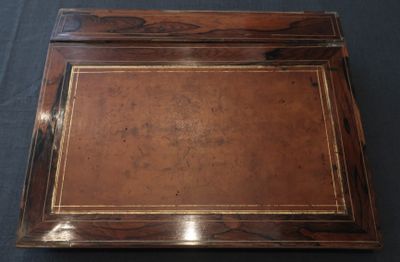 un vieux bureau en bois avec un plateau en cuir marron et des finitions dorées