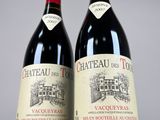 two bottles of red wine sitting next to each other on a table
