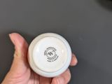 a person holding a small white bowl on a table