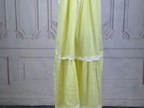 a yellow dress on a mannequin stand on a wooden floor