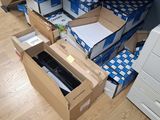 une pile de cartons posée par terre à côté d'une imprimante