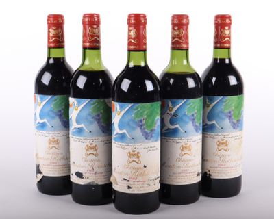 quatre bouteilles de vin sont alignées sur une surface blanche