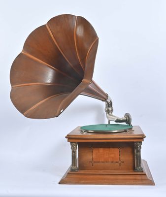 un vieux gramophone posé sur un support en bois, sur fond blanc