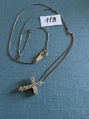 un gros plan d'un collier posé sur un tissu bleu, avec une étiquette de prix