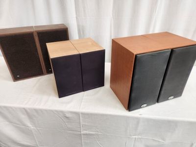 three speakers sitting on top of a table next to each other