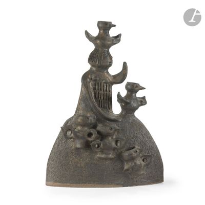 une statue en bronze représentant une femme assise sur un rocher