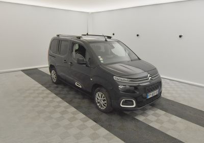 La petite camionnette est garée dans le garage, sur un sol à damier.