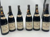 six bottles of wine are lined up in a row on a table