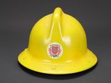 a close up of a yellow fireman ' s helmet on a black background