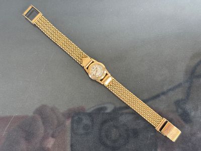 a close up of a gold watch on a table
