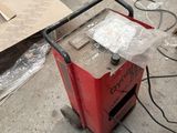 a small red machine that is sitting on the ground