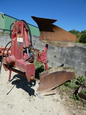 une machine rouge qui est à l'arrêt dans la poussière