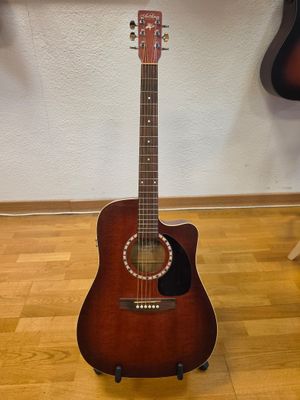 guitar on a stand in front of a wall with a guitar on top of it