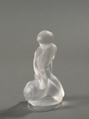 deux figurines en verre représentant un homme et une femme assis sur un rocher